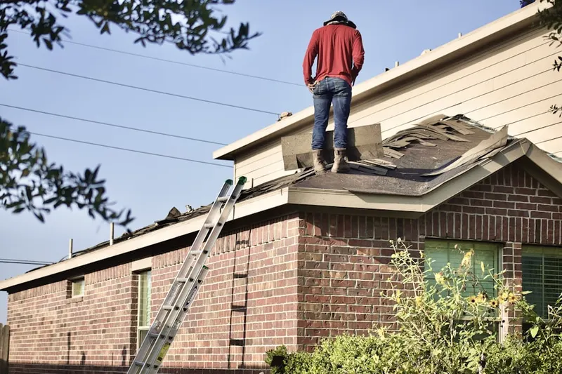 Professional roofer working on a residential roof in Como